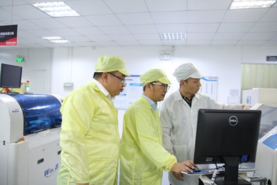 古镇灯饰传媒战略中心总经理杨军与视爵光旭创始人郝宗潮（中）参观视爵光旭生产基地